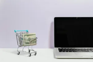 Laptop with shopping cart and money representing affiliate marketing programs