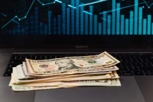 How much does SEO cost in 2026: dollar bills on laptop with financial growth graph representing SEO pricing and ROI for businesses Rank Ray